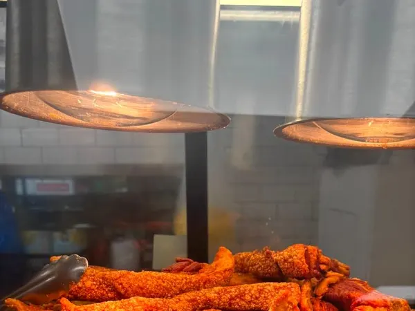 Chicharrón recién hecho bajo lámparas de calor